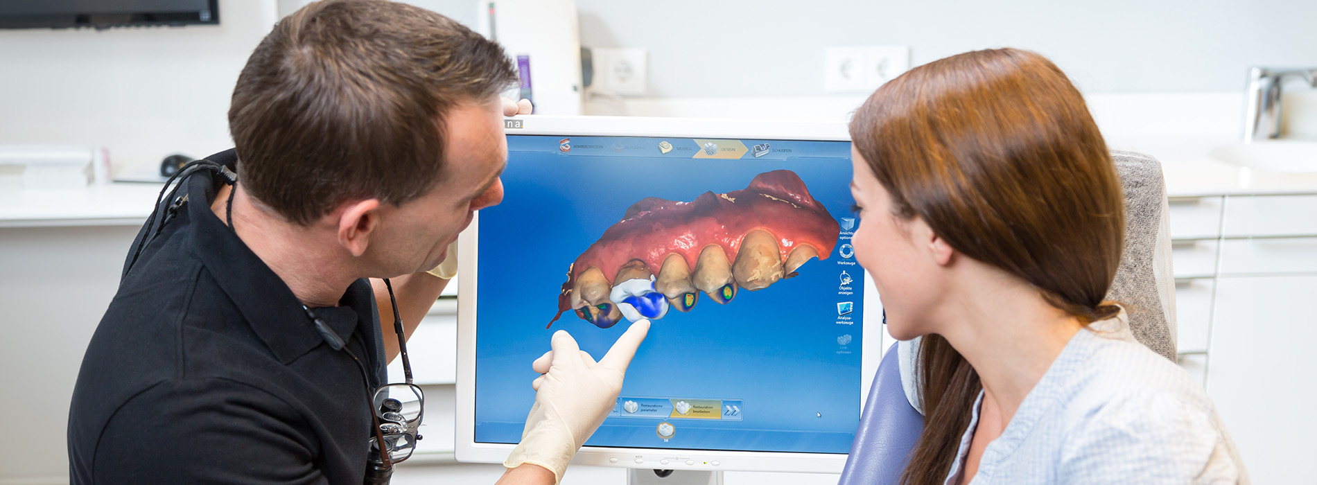 A man and woman are looking at a photo of a large fish, possibly discussing its features with a dentist.