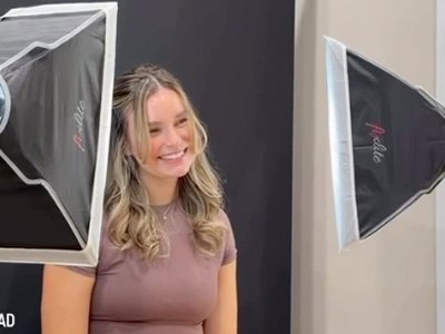 Woman posing with backdrop, smiling at camera.