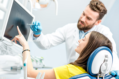 A dentist interacting with a patient in a dental office setting.